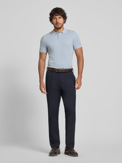 Männermodel trägt Slim Fit Poloshirt Modell 'Triton' von Drykorn, hellblau, reine Baumwolle, Strukturmuster, Ganzkörperansicht von vorne.