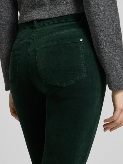 Kobieta ma na sobie spodnie materiałowe 'Slim Fit Stoffhose aus elastischem Baumwoll-Mix' od Christian Berg Woman, ciemnozielony kolor, 5 kieszeni, szlufki na pasek, zapięcie na guzik i zamek błyskawiczny, mieszanka bawełny, krój slim fit, Szerokość w rozmiarze 36/32: 38 cm, Długość wewnętrzna nogawki: 82 cm, widok na tył, zbliżenie na biodra.