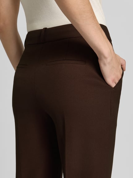 Frauenmodel trägt Slim Fit Schmale Hose mit Viskose-Anteil von GANT w kolorze jednolitym, wpuszczane kieszenie, splot twill, detal: kanty, mieszanka wiskozy, materiał o gładkiej fakturze, widok z tyłu, detal tylny, zbliżenie na spodnie