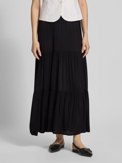 Vrouwenmodel draagt Ausgestellter Maxi-Rock aus reiner Viskose Modell 'MIKKA' van Only, effen kleuren, uitlopend, maxilengte, volants, kreuklook, zuiver viscose, detailopname onderlichaam, vooraanzicht.