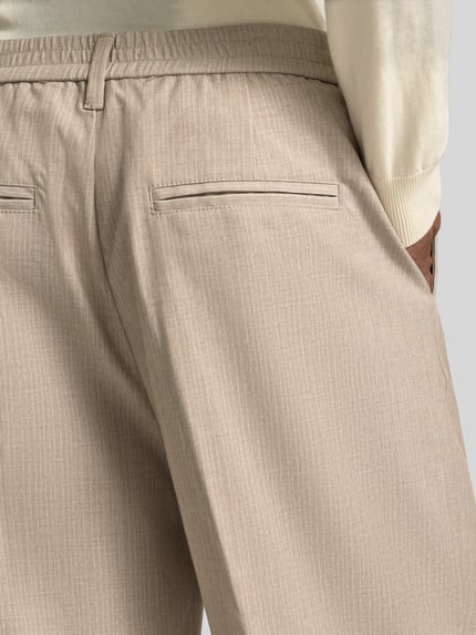 Männermodel trägt Hose mit Streifenmuster und Bügelfalten Modell 'GRANT' von Casual Friday, Material-Mix mit Viskose-Anteil, Detailaufnahme Rückansicht.
