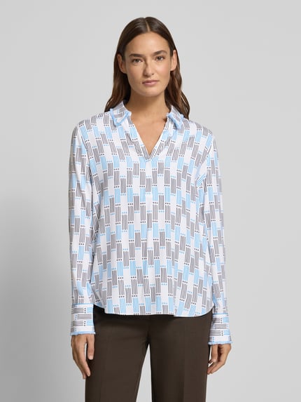 Modelka kobieca nosi Regular Fit Bluse im Allover-Look mit V-Ausschnitt od Herzensangelegenheit, białe i niebieskie wzory, klasyczny kołnierzyk, mix materiałów z dodatkiem stretchu, widok na całą sylwetkę z przodu.