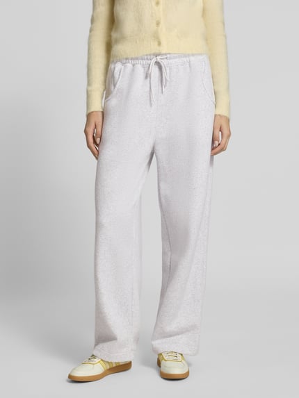 Frauenmodel trägt Sweatpants mit Baumwoll-Anteil Modell 'BAPTOWN' von American Vintage in hellem Farbton, lockere Passform, Ganzkörperansicht von vorne. Damen Sweatpants, Material-Mix, elastischer Bund mit Tunnelzug, Eingrifftaschen, Innenbeinlänge bei Größe M 76 cm.
