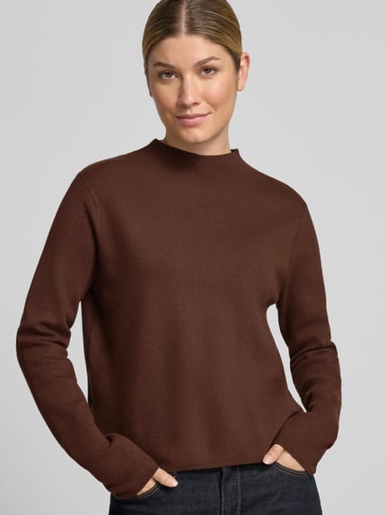 Frauenmodel trägt Strickpullover aus Viskose-Mix Modell 'CHIMNEY' von MANGO in Braun, Regular Fit, glatte Textur, Nahaufnahme Oberkörper.