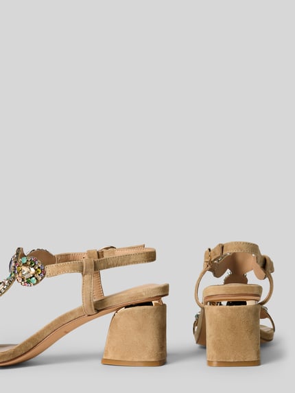 Produktfoto, Sandalette mit Ziersteinbesatz und Blockabsatz von ALMA EN PENA aus Leder-Textil-Mix, Riemen mit Dornschließe, Absatzhöhe 7 cm bei Größe 40, neutrale Sandfarbe, samtige Textur, blockige Form, Produktfoto.