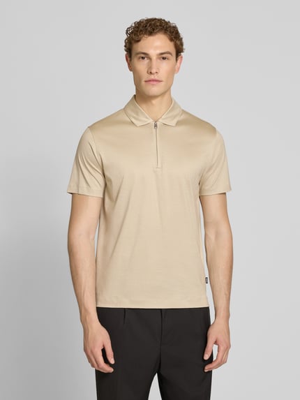 Męski model nosi Regular Fit Poloshirt aus Lyocell-Baumwoll-Mix Modell 'H-PARAS 50' od BOSS, jednolity beżowy kolor, gładka faktura, krój regular fit, polowy kołnierzyk, krótki zamek, krótki rękaw, materiał lyocell-bawelna, zdjęcie: całkowity widok z przodu.
