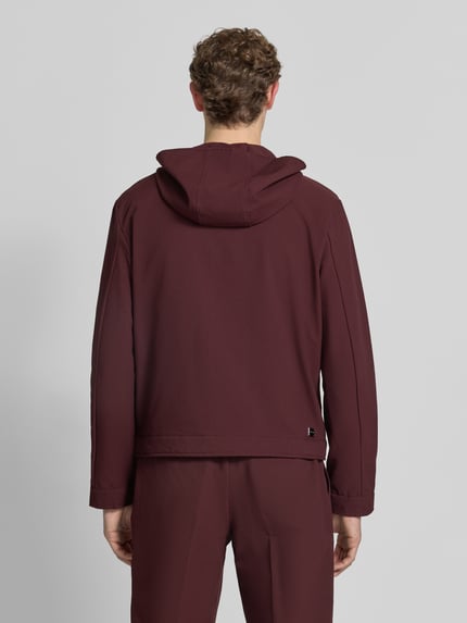 Männermodel trägt Jacke mit Kapuze und Zweiwege-Reißverschluss von Emporio Armani in Dunkelrot, Material-Mix mit Stretch-Anteil, Regular-Fit, Eingrifftaschen, Rückenlänge 66 cm, Schulterbreite 56 cm, Brustweite 58 cm, Ärmellänge 68 cm, Ganzkörperansicht Rückansicht.