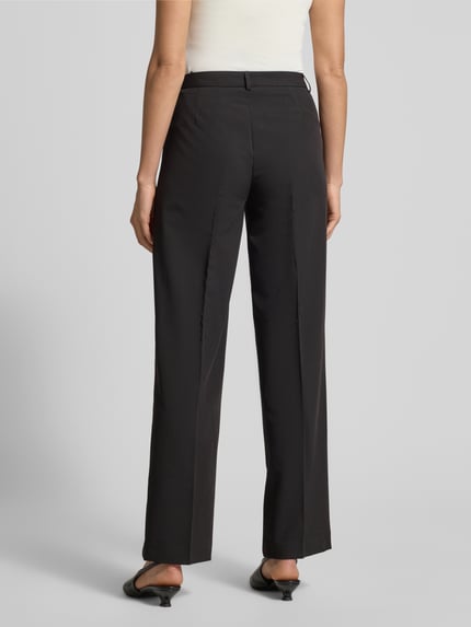 Frauenmodel trägt schwarze Straight Fit Bundfaltenhose mit Viskose-Anteil Modell 'TEXAS' von Vero Moda, Melange-Optik, Ganzkörperansicht Rückansicht.