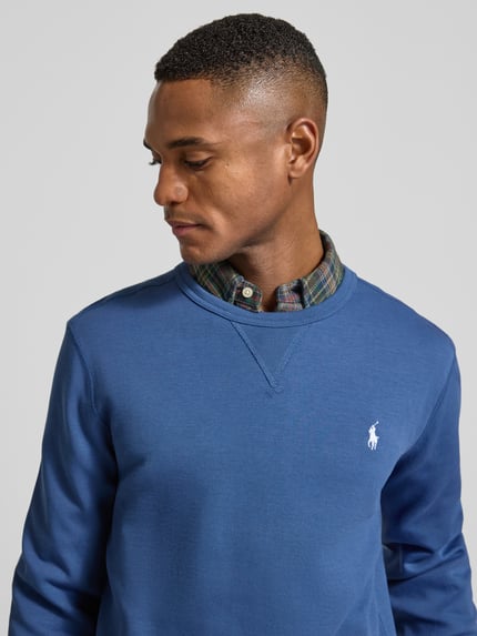 Männermodel trägt Sweatshirt mit Label-Stitching von Polo Ralph Lauren, Baumwoll-Mix, Regular-Fit, Rundhalsausschnitt, Nahaufnahme Oberkörper.