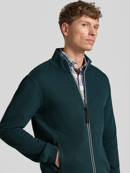 Męski model nosi Regular Fit Jacke aus Baumwoll-Mix Modell 'SELANIK' od LERROS, kolor zielony, detaliczne faktury, zamek błyskawiczny, kieszenie boczne, długość tyłu w rozmiarze M: 69 cm, długość rękawa w rozmiarze M: 65 cm, zdjęcie z przodu, zbliżenie na górną część ciała.