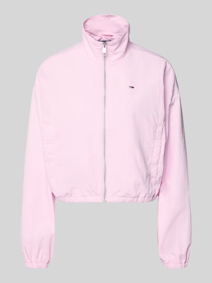 Produktfoto, Relaxed Fit Blouson mit Taillenbändern von Tommy Jeans in hellrosa, einfarbig, Stehkragen, Reißverschluss, lange Ärmel, elastische Bündchen, seitliche Eingrifftaschen mit Druckknopf, Logo-Stitching, glatte Textur
