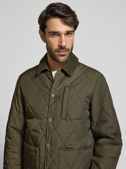 Männermodel trägt Steppjacke mit Umlegekragen aus Cord Modell 'BENJA' von Casual Friday, olivgrün, Regular Fit, Nahaufnahme Oberkörper.