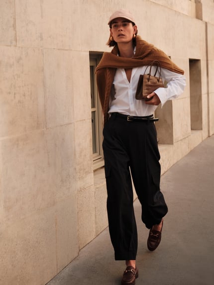 Frauenmodel trägt Cargo-Hose mit weitem Bein – curated by Vera van Erp von Style Icon Collection, schwarzer Stoff, Loose Fit, französische Eingrifftaschen, Gesäßleistentaschen, Material-Mix mit Viskose, Ganzkörperansicht von vorne.