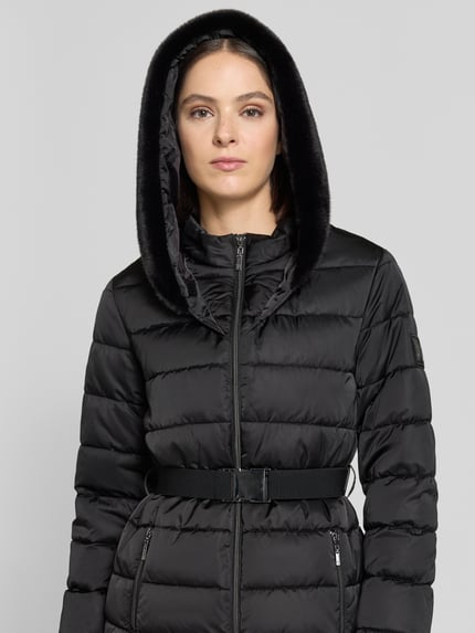 Frauenmodel trägt Jacke in Stepp-Optik von monari in Schwarz mit Kunstfellkapuze, tailliert, Zweiwege-Reißverschluss, Nahaufnahme Oberkörper.
