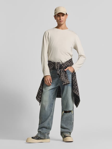 Männermodel trägt Straight Fit Jeans im Destroyed-Look von Don't Waste Culture, Blautöne, 5-Pocket-Design, Baumwoll-Elasthan-Mix, Ganzkörperansicht von vorne.