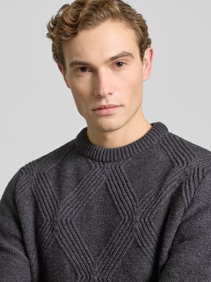 Männermodel draagt Strickpullover mit gerippten Abschlüssen van Forét, donkergrijze katoenmengsel, losse pasvorm, ronde hals, Nahaufnahme bovenlichaam.