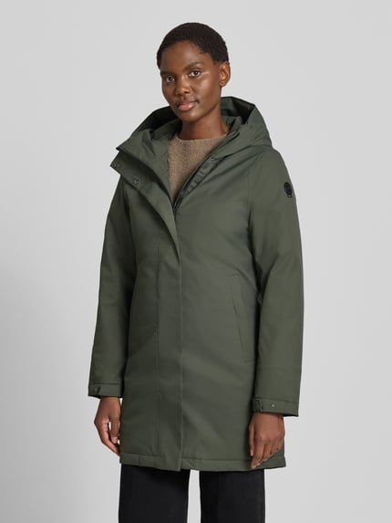 Frauenmodel trägt Parka mit 10.0000mm Wassersäule von G.I.G.A. DX in Olivgrün, verdeckter Reißverschluss, Ganzkörperansicht von vorne. Regular Fit, Kapuze, Eingrifftaschen, Ärmelriegel, Rückenlänge 88 cm, Schulterbreite 42 cm, Brustweite 49 cm, Ärmellänge 64 cm.