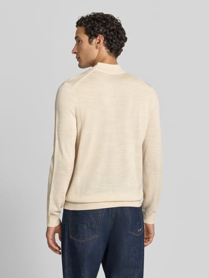 Männermodel trägt Regular Fit Turtleneck aus Woll-Mix von Christian Berg Men in Beige mit gerippten Abschlüssen, Ganzkörperansicht Rückansicht.