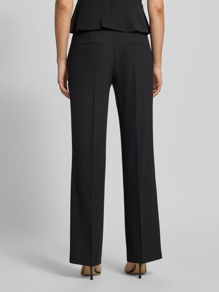 Vrouwenmodel draagt Straight Fit Hose met bandplooien van HUGO, look: effen, pasvorm: straight fit, bandplooien, knoop- en ritssluiting, zij-steekzakken voor, stoffen damesbroek, Ganzkörperansicht Rückansicht.