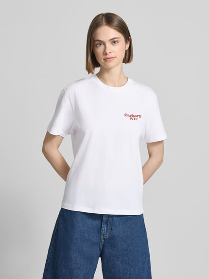 Kobiecy model nosi damski t-shirt z bawełny, prosty krój, okrągły dekolt, nadruk z logo, model 'Spoiled' od Carhartt Work In Progress, długość tyłu 58 cm w rozmiarze S, widok całej sylwetki od przodu.