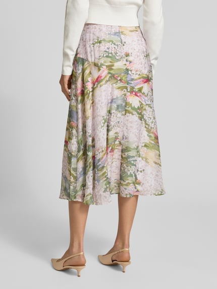 Frauenmodel trägt Midirock mit Reißverschluss Modell 'LAYDA' von Ted Baker im floralen Muster, A-Linie, Lyocell-Mix, Ganzkörperansicht Rückansicht.