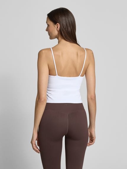Frauenmodel trägt Top mit Stretch-Anteil und Shaping-Effekt von aim'n, weiß, eng anliegend, Spaghettiträger, Ganzkörperansicht Rückansicht.
