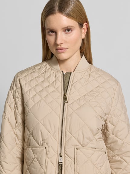 Frauenmodel trägt Steppjacke mit Eingrifftaschen von Fuchs Schmitt, beige Farbe, gesteppte Struktur, Nahaufnahme Oberkörper.