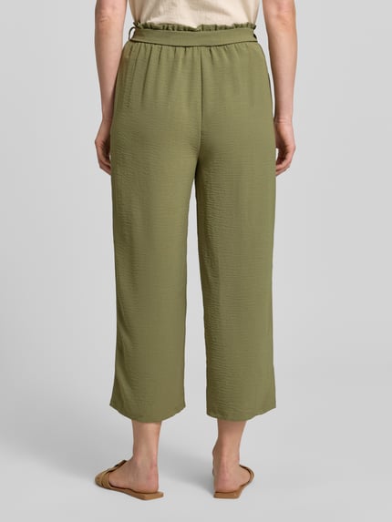 Frauenmodel trägt Culotte mit Bindegürtel Modell 'JOSA' von Vila in Olivgrün, Loose-Fit, elastischer Bund, Seitliche Eingrifftaschen, Ganzkörperansicht Rückansicht. Bundweite 35 cm, Innenbeinlänge 91 cm bei Größe 36. Strukturierte Textur.