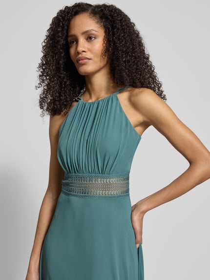 Frauenmodel trägt Abendkleid mit Raffungen von Jake*s Cocktail, taillierter Schnitt, Spaghettiträger, blickdichtes Unterkleid, Nahaufnahme Oberkörper.