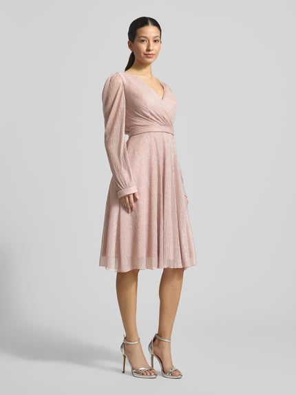 Vrouwenmodel draagt Regular Fit Jurk in wikkellook van TROYDEN COLLECTION, glitter mesh, V-hals, getailleerd, met lange mouwen, geheel vooraanzicht