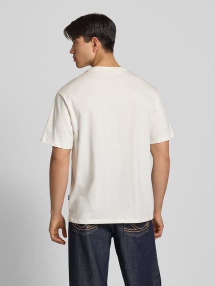 Männermodel trägt Oversized T-Shirt Modell 'FISHER' von Blend in Weiß, reine Baumwolle, strukturierte Oberfläche, Ganzkörperansicht Rückansicht.