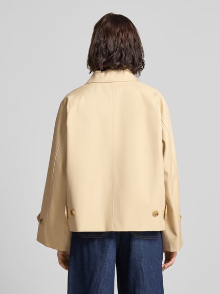 Frauenmodel trägt Jacke mit Ärmelriegeln Modell 'CUBA' von Mango in Beige, Reine Baumwolle, Relaxed-Fit, Rückenlänge 60 cm, Ganzkörperansicht Rückansicht.