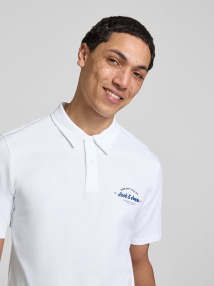 Männermodel trägt weißes Poloshirt mit Label-Print Modell 'BRANDON' von Jack & Jones, Reine Baumwolle, Regular-Fit, Nahaufnahme Oberkörper.