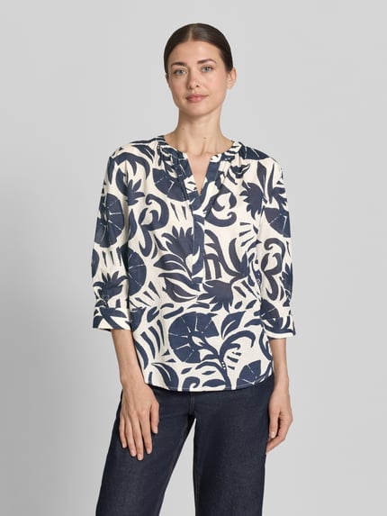 Frauenmodel trägt Bluse mit Tunikakragen und 3/4-Arm von Oui, Reine Baumwolle, Gerader-Schnitt, florales Muster, abgerundeter Saum, Ganzkörperansicht von vorne.