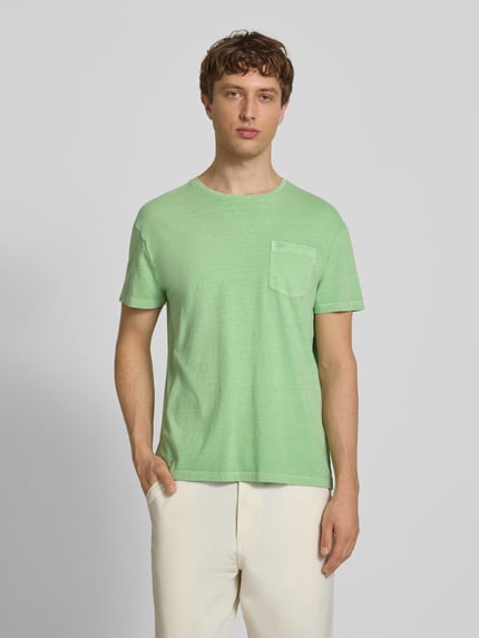 Männermodel trägt T-Shirt aus Baumwoll-Leinen-Mix mit Brusttasche von Superdry in Grün, Regular-Fit, Rundhalsausschnitt, Herren T-Shirt, Rückenlänge bei Größe M 66 cm, Ganzkörperansicht von vorne.