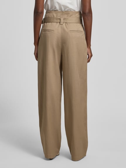 Vrouwenmodel draagt Regular Fit wijdte broek met geïntegreerde riem van Marc O'Polo, look: effen, lyocellmix, bandplooien, paspelzakken, high waist, wide leg, zij-steekzakken, riemlussen, knoop- en ritssluiting. Volledige lichaamsopname van achteren.