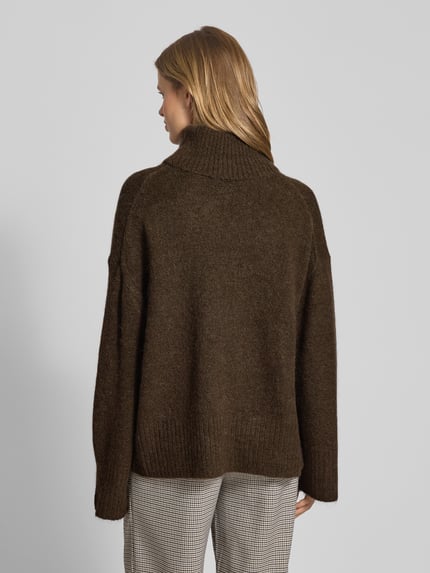 Vrouwenmodel draagt Oversized Strickpullover mit Rollkragen van Gina Tricot, bruin, geribde boorden, katoenmix, geheel van achteren gezien.