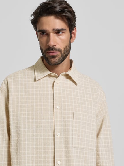 Männermodel draagt Freizeithemd mit Knopfleiste Modell 'Carter' van Wood Wood in beige ruit, katoenmix, borstzak, Nahaufnahme bovenlichaam.