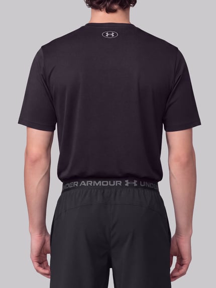 Männermodel trägt schwarze Regular Fit Sportshorts mit Logo-Print von Under Armour, glattes Material, Ganzkörperansicht Rückansicht. Herren Sportshorts von Under Armour.