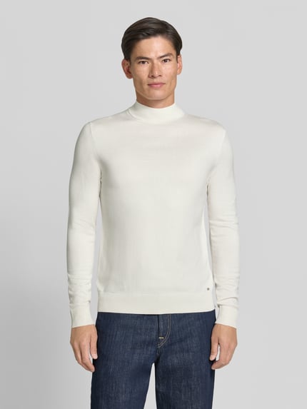 Männermodel trägt Rollkragenpullover mit Viskose-Anteil von MARKUP in creme, gerader Schnitt, gerippte Abschlüsse, Ganzkörperansicht von vorne.