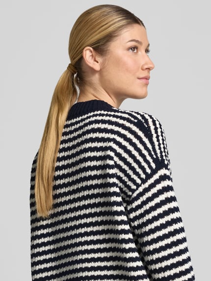 Männermodel trägt Loose Fit Pullover aus reiner Schurwolle Modell 'SPIGA' von Weekend Max Mara, gestreiftes Strickmuster, Nahaufnahme Oberkörper