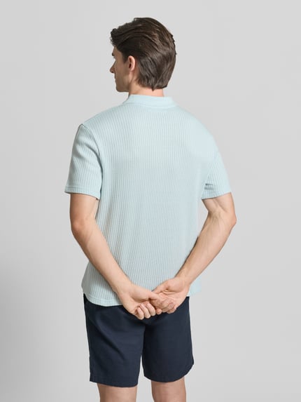 Männermodel trägt Regular Fit Poloshirt aus reiner Baumwolle Modell 'JASE' von Samsøe Samsøe in Hellblau mit Struktur, Ganzkörperansicht Rückansicht.
