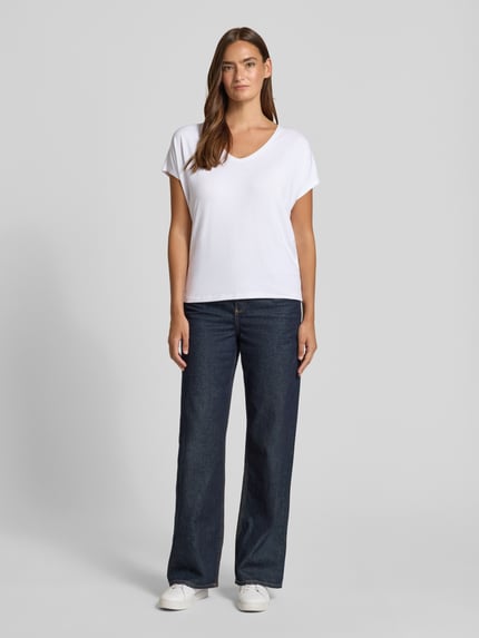 Modelka nosi Relaxed Fit T-Shirt aus Viskose-Mix od s.Oliver RED LABEL, biały, ciemnoniebieskie spodnie, gładka faktura, pełny widok z przodu.