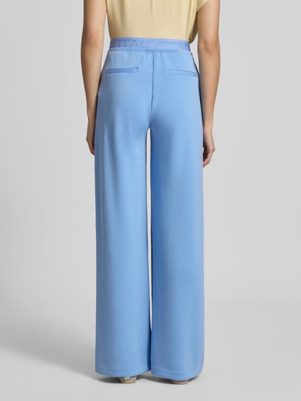 Frauenmodel trägt Sweatpants mit Stretch-Anteil von Milano Italy in Hellblau, weiter Schnitt, Modal-Elasthan-Mix, Ganzkörperansicht Rückansicht.