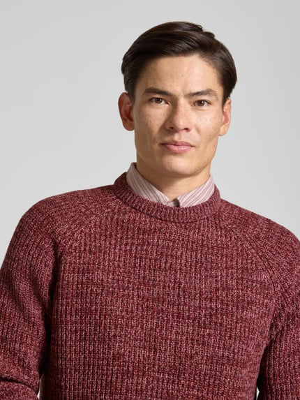 Männermodel trägt Strickpullover aus reiner Baumwolle Modell 'BARBOUR HORSEFORD' von BARBOUR in melierter Strickoptik, Nahaufnahme Oberkörper.