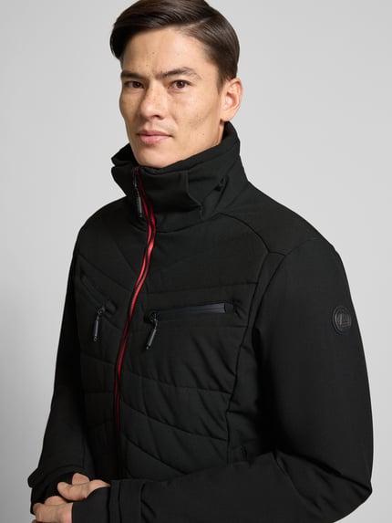 Männermodel trägt schwarze Steppjacke mit Kapuze Modell 'KARRAVAARA' von LUHTA mit Reißverschlussdetails, Nahaufnahme Oberkörper.
