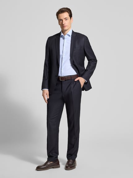 Männermodel trägt Slim Fit Business-Hemd mit Haifischkragen von Seidensticker, Material-Mix mit Stretch-Anteil, Ganzkörperansicht von vorne.