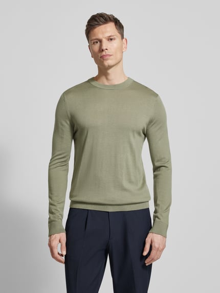 Männermodel trägt Regular Fit Pullover aus reiner Wolle Modell 'TRAY' von SELECTED HOMME, unifarben, Feinstrick, Ganzkörperansicht von vorne.