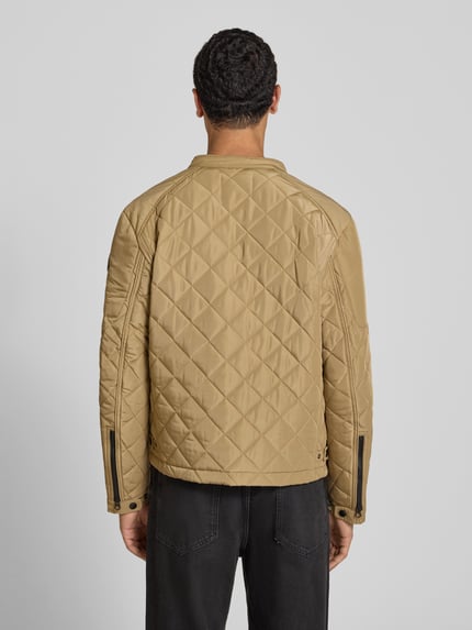Männermodel trägt Regular Fit Jacke in Stepp-Optik von Replay in Beige mit Stehkragen und Reißverschlusstaschen, Ganzkörperansicht Rückansicht. Rückenlänge bei Größe M: 65 cm, Schulterbreite: 29 cm, Brustweite: 38 cm, Ärmellänge: 63 cm.