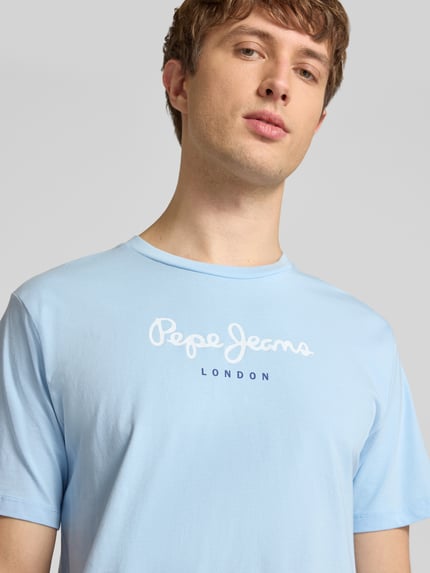 Männermodel trägt Regular Fit T-Shirt aus reiner Baumwolle Modell 'EGGO' von Pepe Jeans in Optik: Unifarben, Label-Print, Rundhals, Jersey, Nahaufnahme Oberkörper.